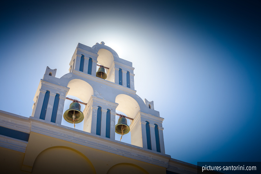 Belltower against the summer sun in Firostefani, Santorini