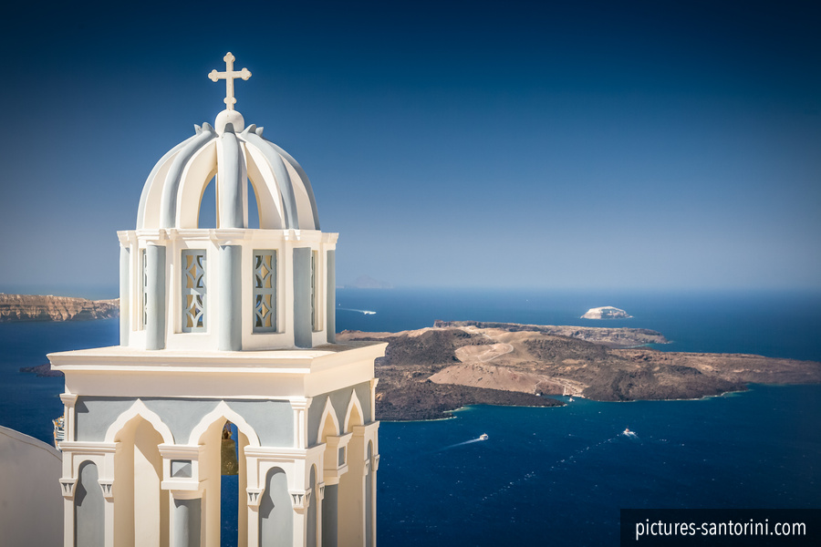 Bell tower in Firostefani, Santorini in front of the caldera. In the background the volcano island of Nea Kameni