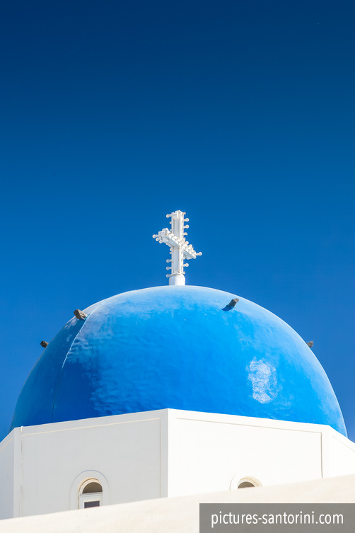 Typical blue domed church against the deep blue sky. Picture was photographed in Firostefani, Santorini