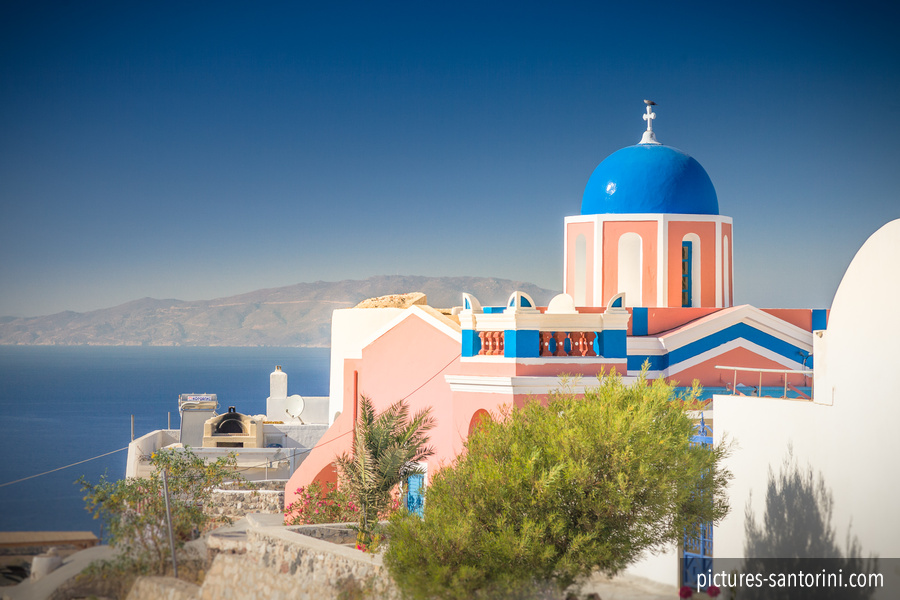 Colorful church building in Oia, Santorini / Greece in front of the Aegean Sea