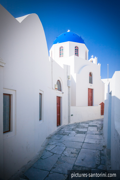 A white-and-blue church in Oia, Santorini, photographed against a clear Mediterranean sky